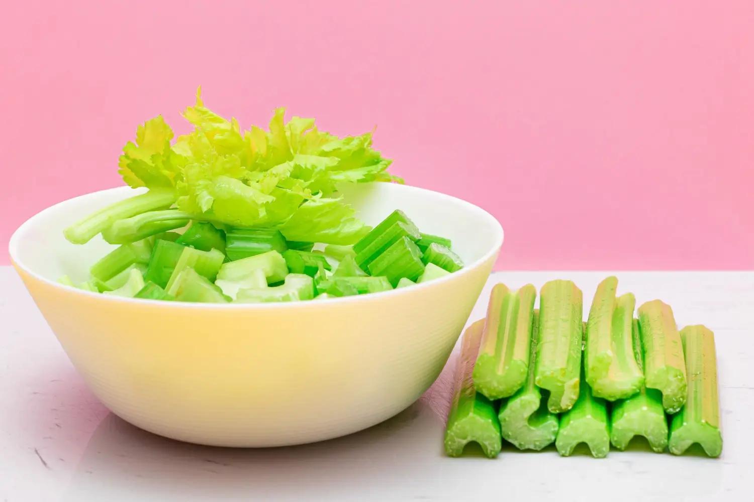 Miska s nakrájenými zelenými řapíky celeru a čerstvými listy