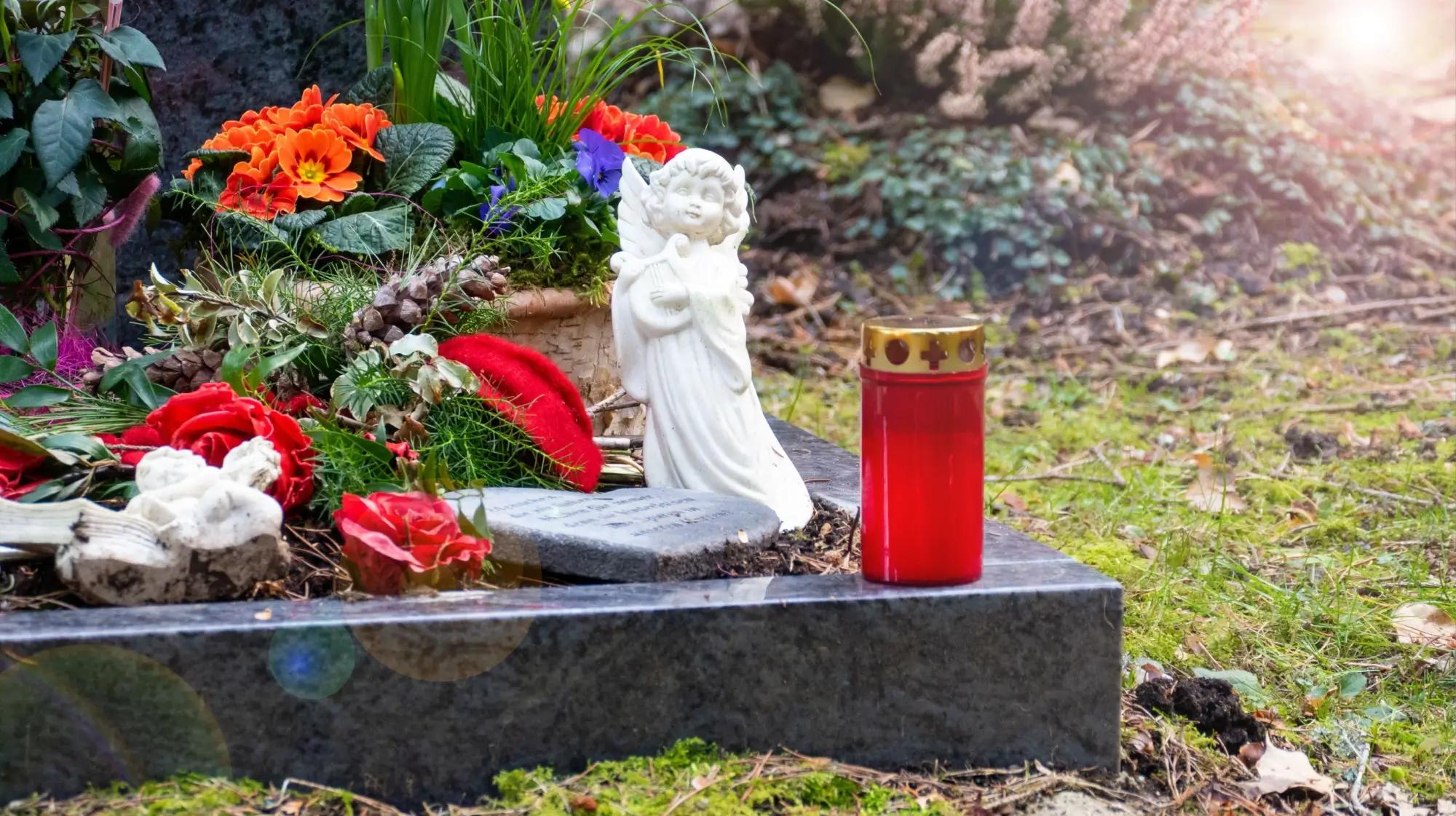 Hrob, ozdobený sádrovým andělíčkem a plastovými svíčkami není úplně podle feng-shui.